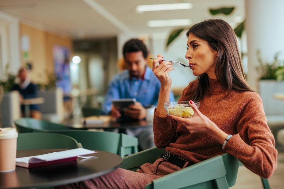 Mujer almorzando en la oficina.