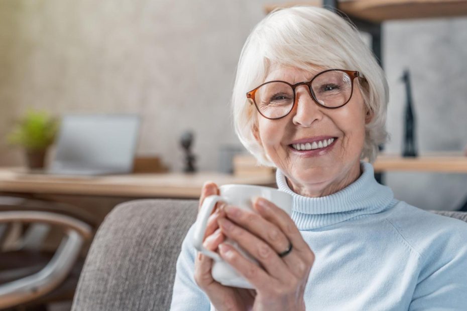 Una mujer mayor bebiendo café.