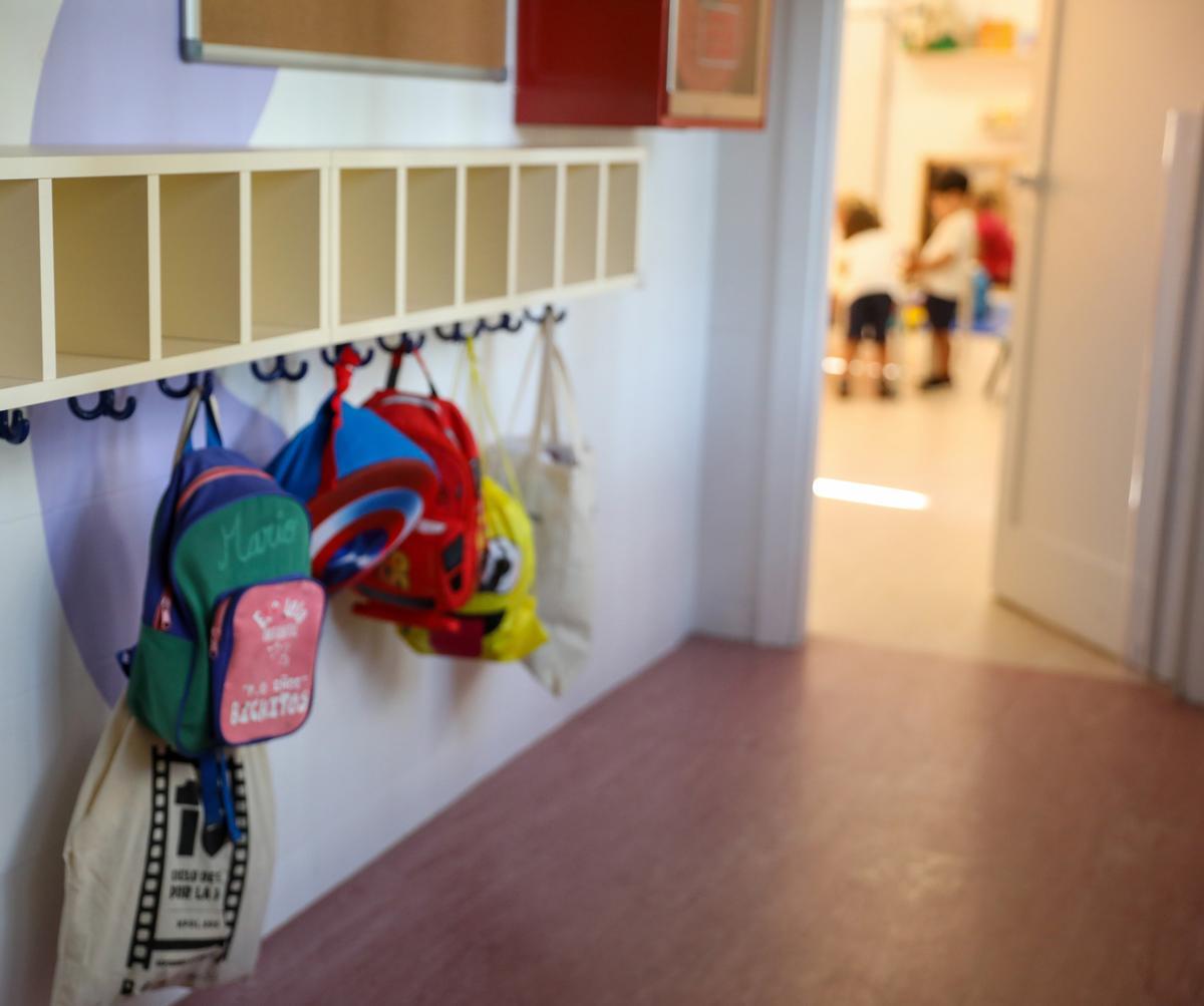 Varias mochilas en una percha de un aula de 3 años en un colegio público madrileño el primer día de clase.