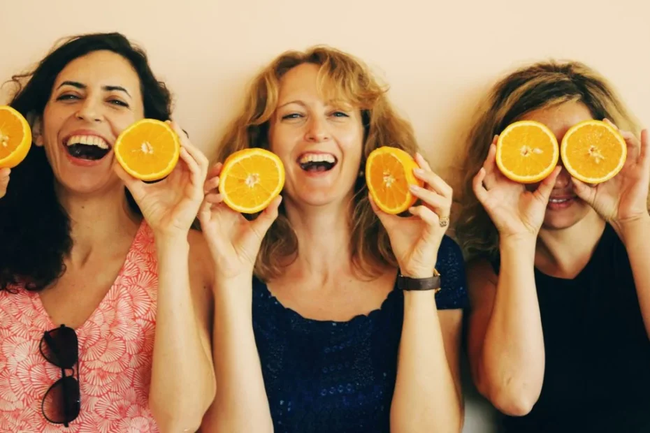 Mujeres sonrientes sosteniendo medias naranjas